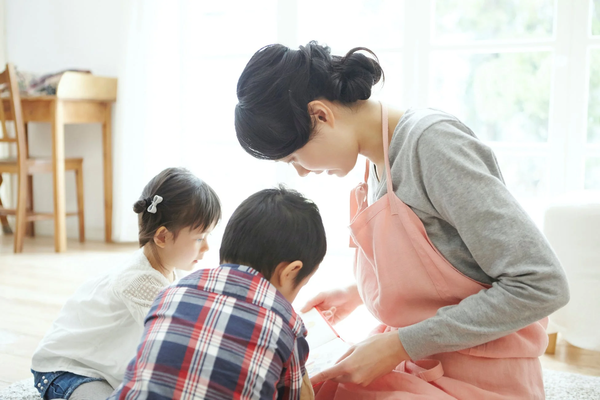親子が室内で絵本を見ている様子