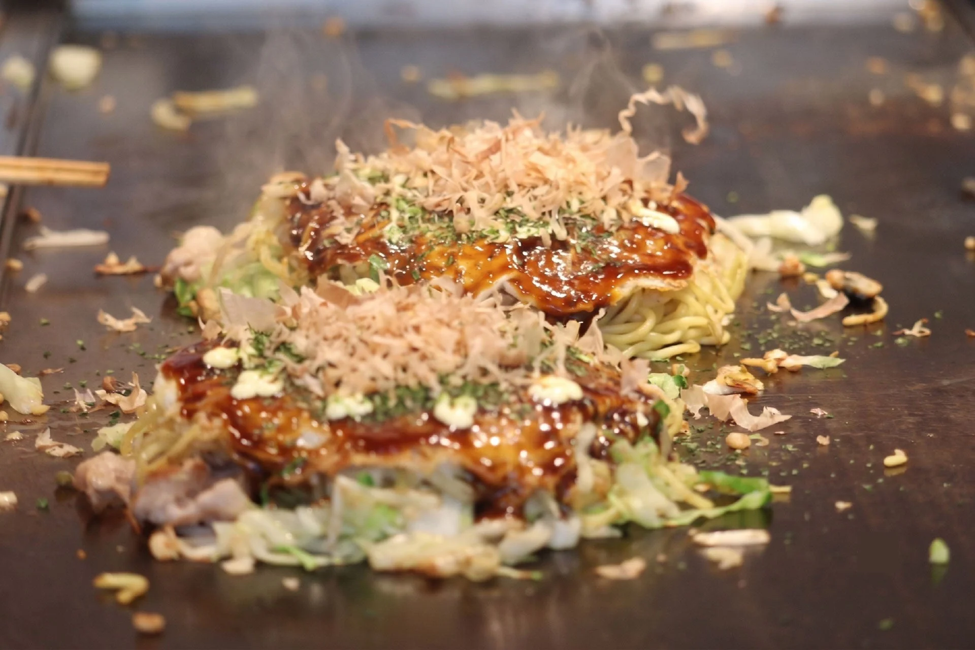 鉄板で調理されたお好み焼き