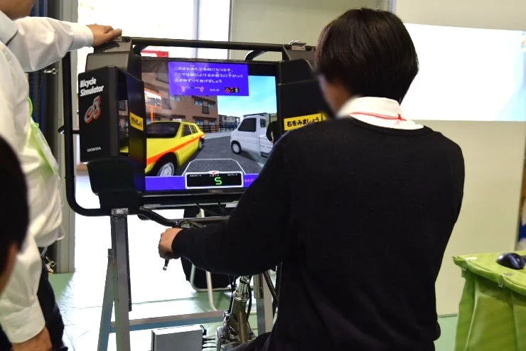 自転車シミュレーターを体験する高校生
