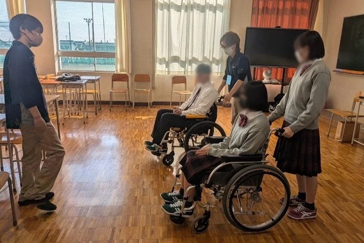 車椅子体験をする高校生