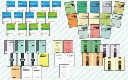 TACの様々な資格試験の教材や参考書、問題集、申請書のような書類が多数並べられている画像です。