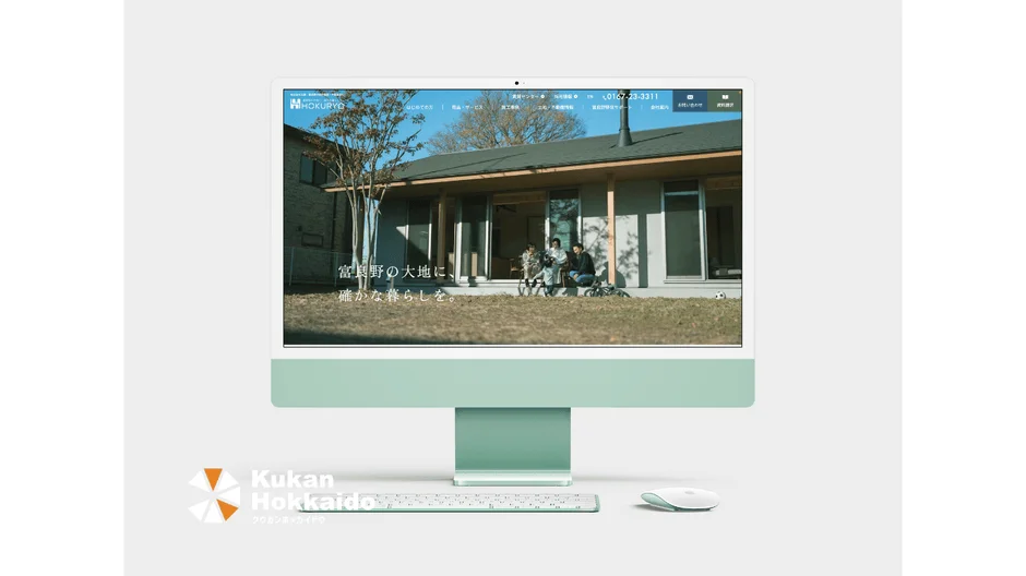ライトグリーンのiMacの画面に、住宅会社のウェブサイト