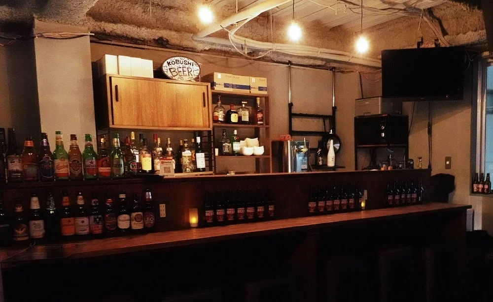 「KOBUSHI BEER」の看板があるバーカウンターの風景。