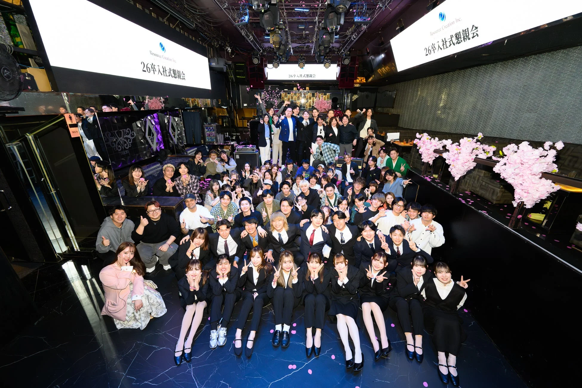 入社式懇親会で集合写真を撮る社員たち